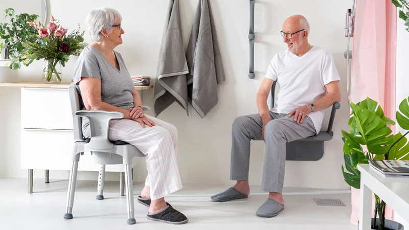 gospod in gospa sedita na stolih s toaletno povišico HI-LOO